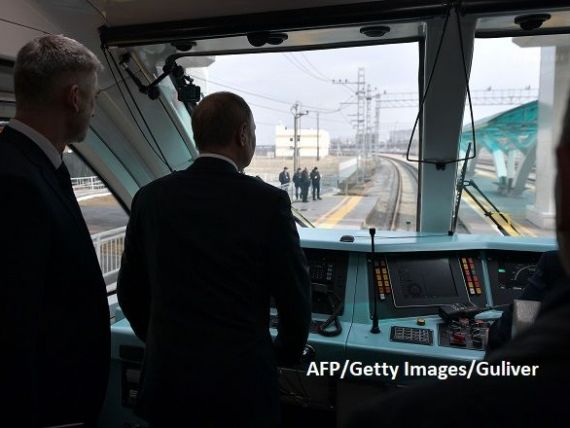 Putin, mecanic de locomotivă . Liderul de la Kremlin a inaugurat linia ferată care leagă Crimeea de Rusia continentală din cabina primului tren care a parcurs-o